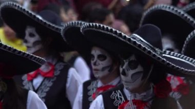 Mexico City, Kasım 2019. Kafatası ve mariachi kostümünden yapılmış bir grup genç Mexico City 'deki Ölüler Günü geçit töreninde davul çalıyor..