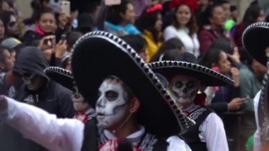 Mexico City, Kasım 2019. Kafatası ve mariachi kostümünden yapılmış bir grup genç Mexico City 'deki Ölüler Günü geçit töreninde davul çalıyor..