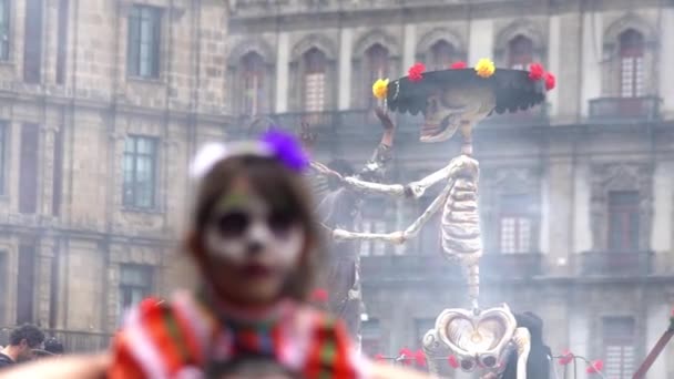 2019年11月 墨西哥城 在墨西哥城的 死亡日 庆典上 一个化着卡特里娜妆的女孩站在他父亲的肩上 背面是一个巨大的硬纸板骷髅木偶 — 图库视频影像
