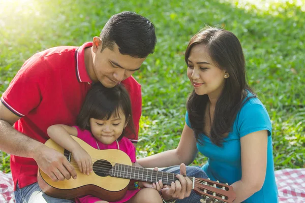 Papai Ensinando Sua Filhinha Tocar Guitarra Enquanto Mãe Assiste — Fotografia de Stock