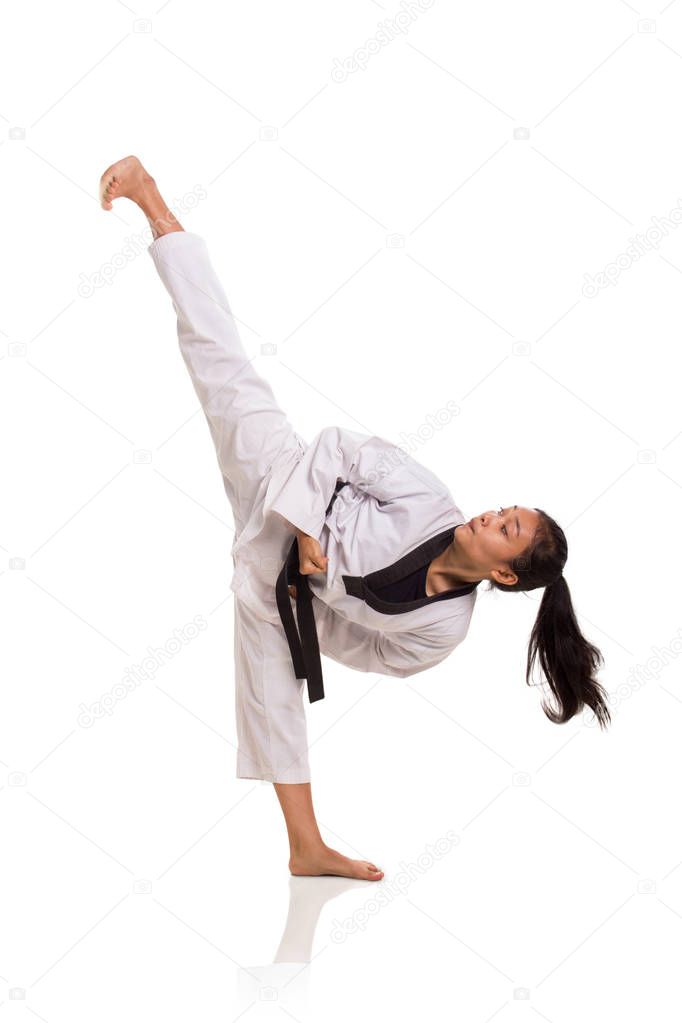 Taekwondo girl high kick, full length portrait isolated over white background