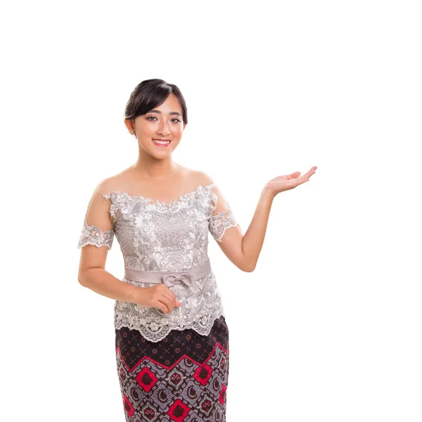 美丽的亚洲女孩的肖像在民族服装 友好的建议或提出的东西与她的左臂 孤立在白色的背景 — 图库照片