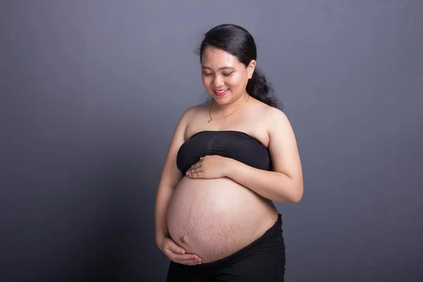 Durante Maternidad Atractiva Mujer Asiática Embarazada Con Ropa Negra Acariciando Imagen De Stock