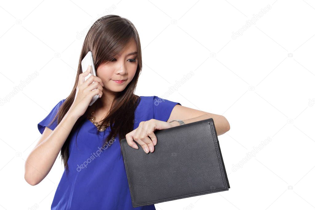 Urban woman with busy lifestyle concept, checking time on her watch while making phone call, over white background