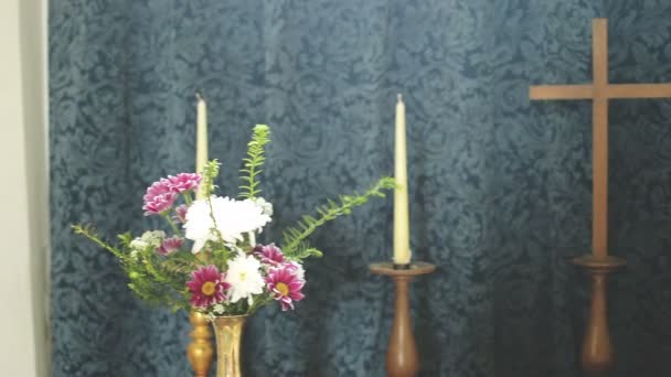 教堂木十字架在蜡烛和花之间 — 图库视频影像
