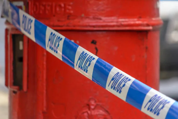 British Police Tape In Front Of Red Post Box, Shallow Depth of Field
