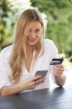 Bir akıllı telefon ile online satın alma bir gülümseyen kadın portresi 