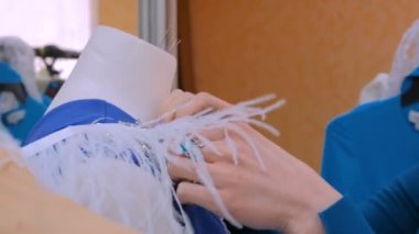 İki moda tasarımcısı yeni manken terzisi elbisesiyle çalışıyor.