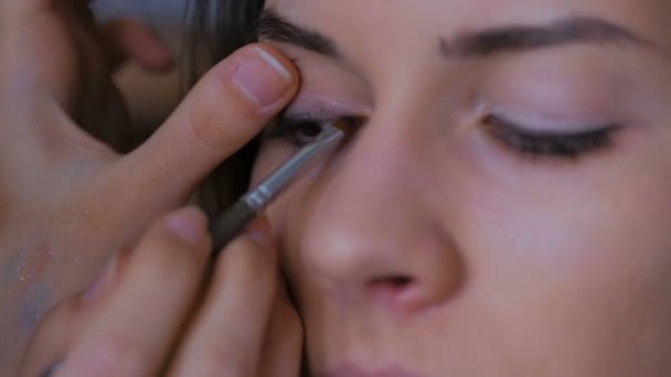 Professionell make-up artist tillämpa eyeliner runt hela ögat av modell — Stockvideo