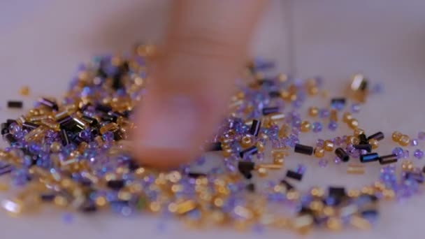 Woman hand sorts out colorful beads — Stock Video