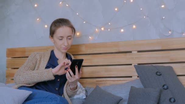 Vrouw met verticale zwarte smartphone thuis — Stockvideo