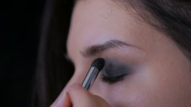 Profesyonel makyöz göz farı kullanıyor.