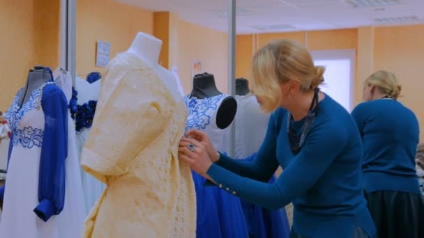 Tres disparos. Diseñador de moda trabajando con nuevo modelo vestido de sastrería en el maniquí — Vídeos de Stock