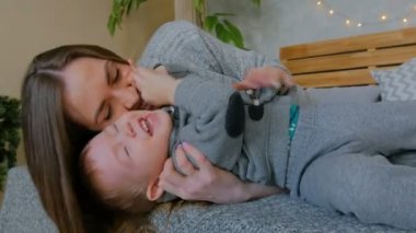 Mutlu genç anne ve küçük oğlu birlikte oynuyorlar.