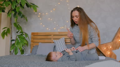 Mutlu genç anne ve küçük oğlu birlikte oynuyorlar.
