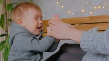 Mutlu genç anne ve küçük oğlu birlikte oynuyorlar.
