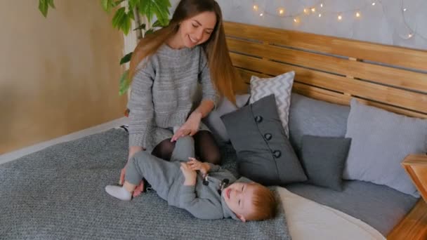 Счастливая молодая мать и ее маленький сын играют в игрушки — стоковое видео