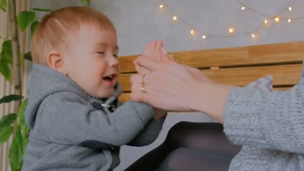 Счастливая молодая мать и ее маленький сын играют в игрушки — стоковое видео