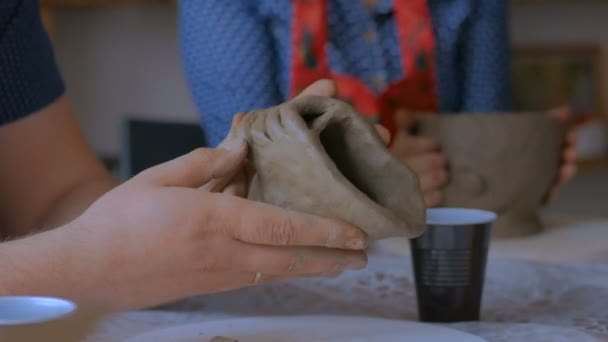 5 выстрелов. Человек показывает, как сделать глиняную кружку в керамической студии — стоковое видео