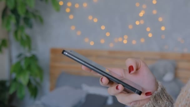 Mujer usando teléfono inteligente negro vertical en casa — Vídeo de stock