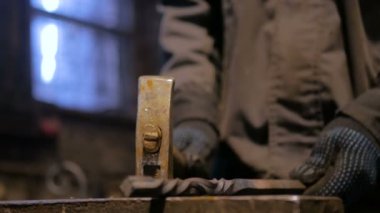 Demirci metalle çalışıyor.