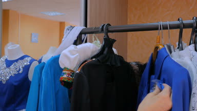 Kadınların elleri askı ile elbiseler çözer