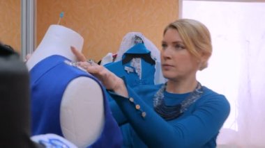 İki moda tasarımcısı yeni manken terzisi elbisesiyle çalışıyor.