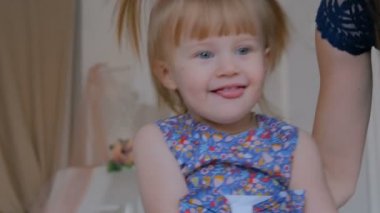 Küçük kız tahta sallanan atta oynuyor.