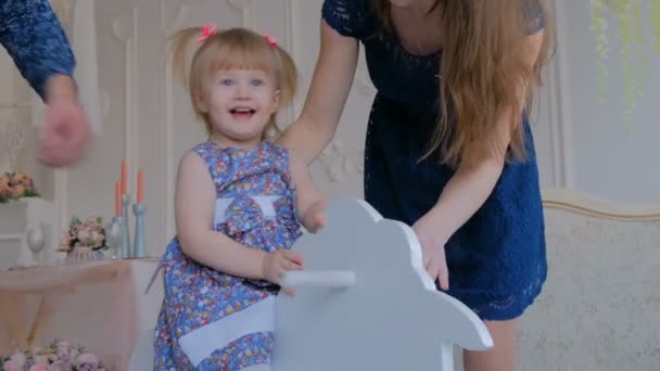 Niña jugando en madera mecedora caballo — Vídeos de Stock