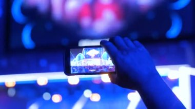 Akıllı telefonlu canlı müzik konserinin görüntülerini kaydeden eller.