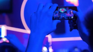 Akıllı telefonlu canlı müzik konserinin görüntülerini kaydeden eller.