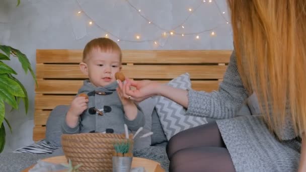 Jovem mãe feliz e seu filho bebê brincando com nozes — Vídeo de Stock