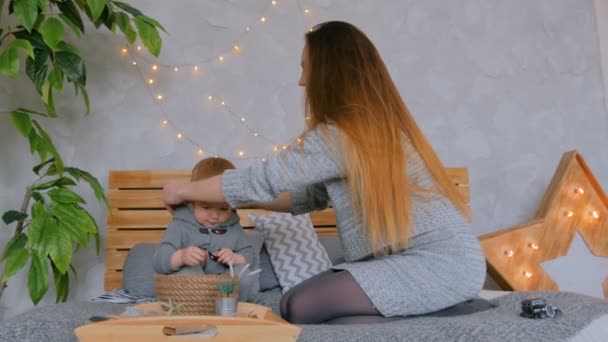 Счастливая молодая мать и ее маленький сын играют с грецкими орехами — стоковое видео