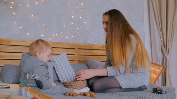 Lycklig ung mor och hennes son leker med valnötter — Stockvideo