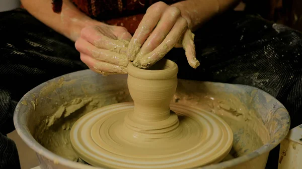 Professional male potter making ceramics in workshop