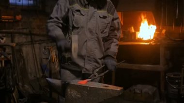 Demirci metalle çalışıyor.