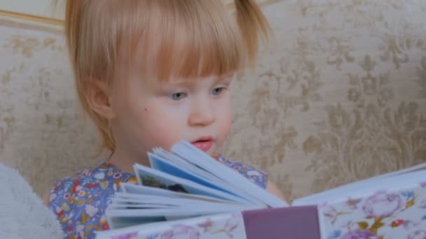 Niña mirando fotolibro — Vídeos de Stock