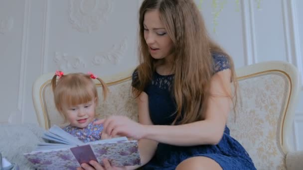 Νεαρή Μητέρα Και Κόρη Της Αναζητούν Photobook Togerher Στο Σπίτι — Αρχείο Βίντεο