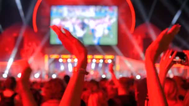 Люди силуетні вечірки і чіпляються на нічному електронному музичному концерті перед сценою — стокове відео