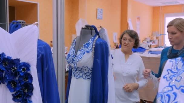 Dois designers de moda que trabalham com novo modelo de alfaiataria vestido no manequim — Vídeo de Stock