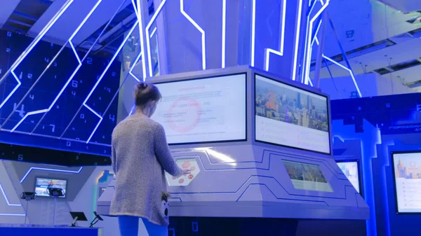 Şehir sergisinde etkileşimli dokunmatik ekran kullanan kadın
