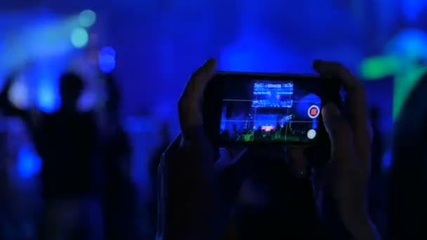 Händer silhuett inspelning video av levande musik konsert med smartphone — Stockvideo