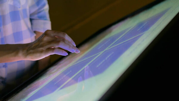 Женщина с интерактивным сенсорным экраном в современном музее
