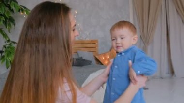 Mutlu genç anne ve küçük oğlu birlikte oynuyorlar.