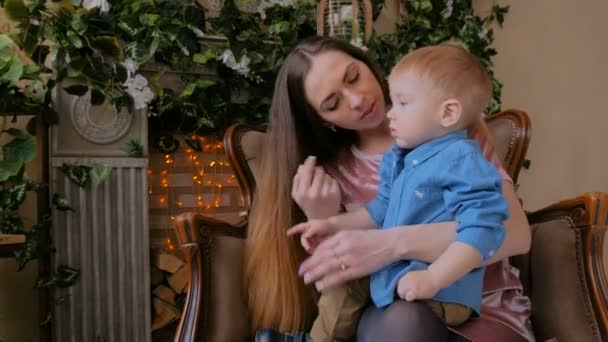 Glückliche junge Mutter und ihr kleiner Sohn sitzen zusammen — Stockvideo