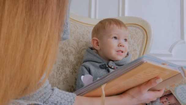 3 Schüsse. junge Mutter und ihr kleiner Sohn suchen Fotobuch — Stockvideo