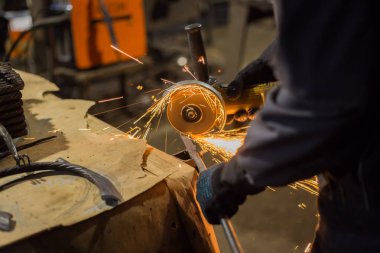 Demirci el testeresiyle metal kesiyor.