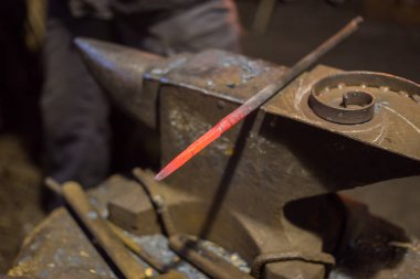 Demirci metalle çalışıyor.