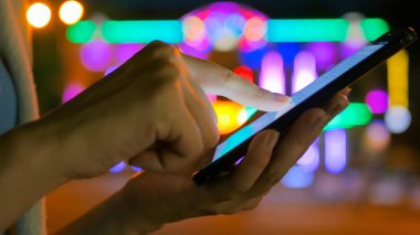 Şehirde akıllı telefon kullanan bir kadın.