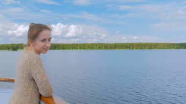 Cruise gemi güverte üzerinde duran ve nehirde seyir genç kadın